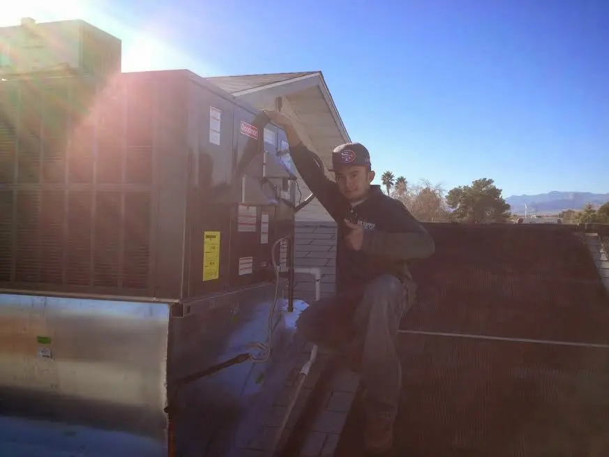 HVAC technician performing HVAC Inspection on a rooftop unit in Farragut